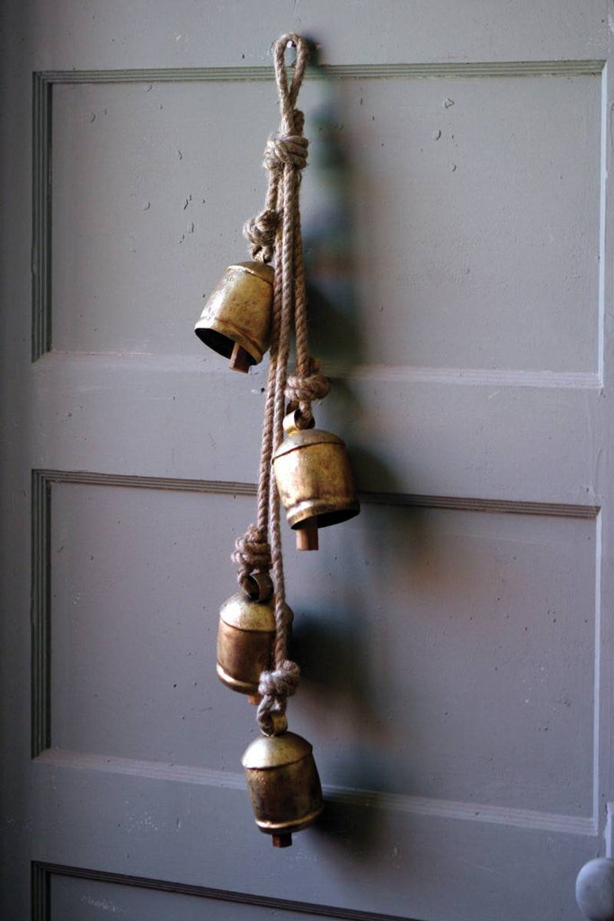 4 rustic iron cow bells hanging on rope