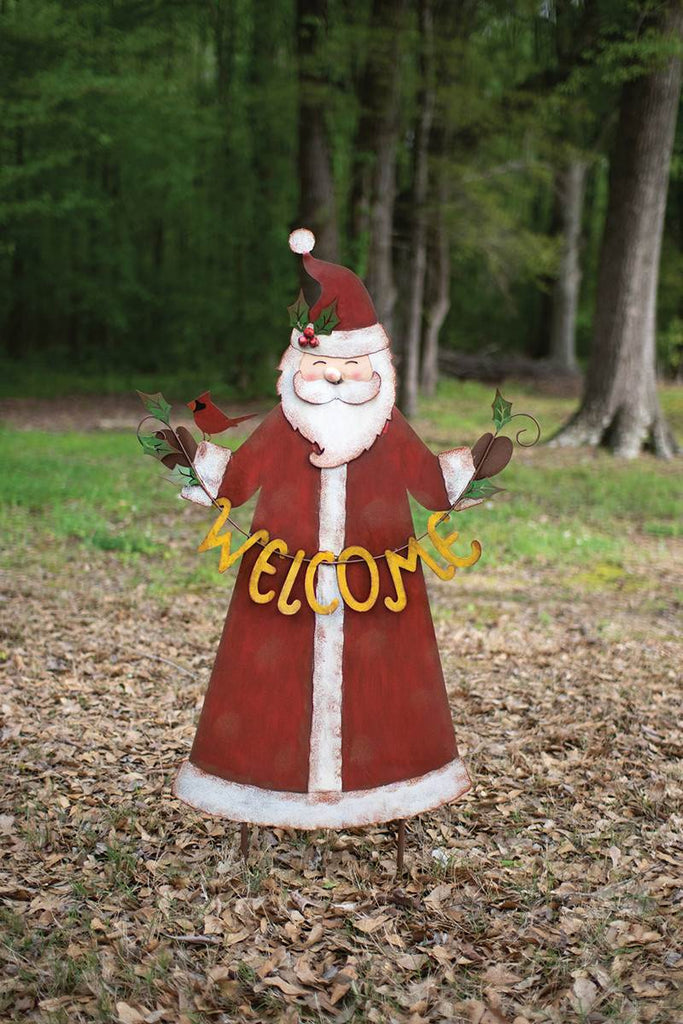 painted metal santa with welcome sign in front of wooded area