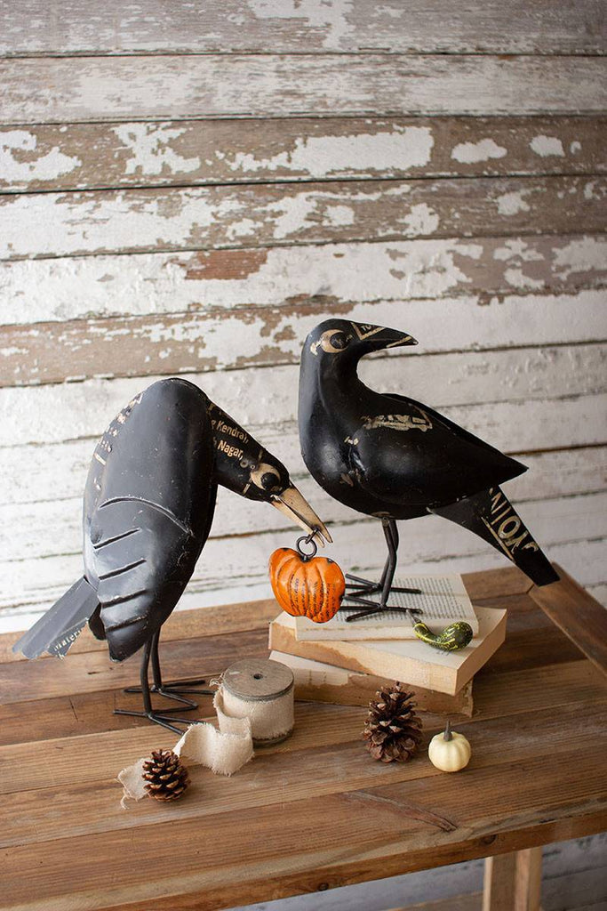 two black iron crows one holding a pumpkin
