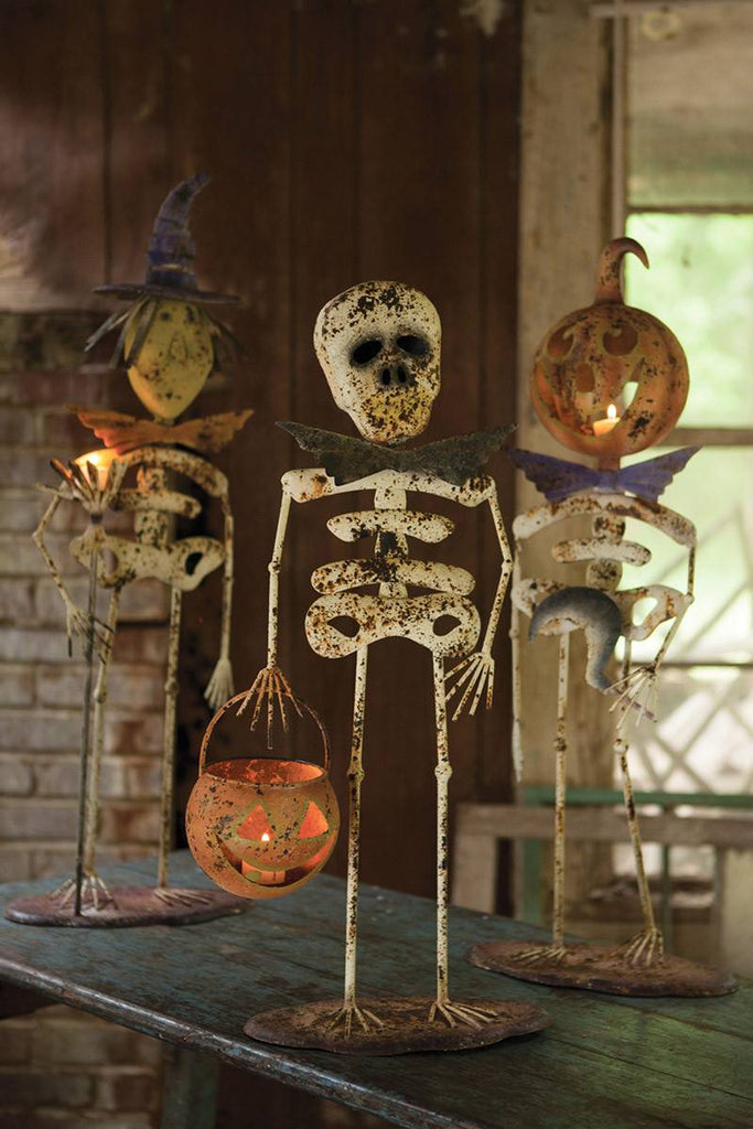 a witch a pumpkin man and a regular skeleton for halloween decor