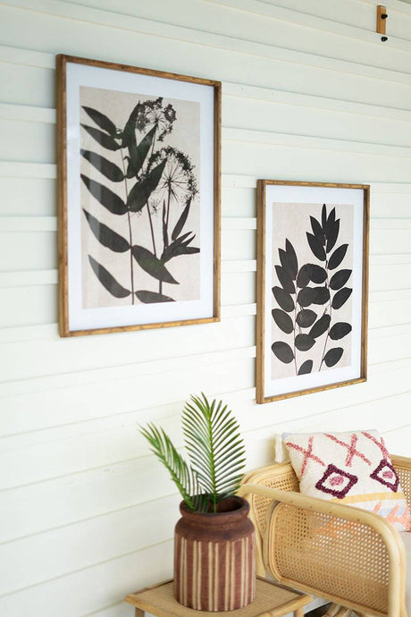 two black leaf prints under glass